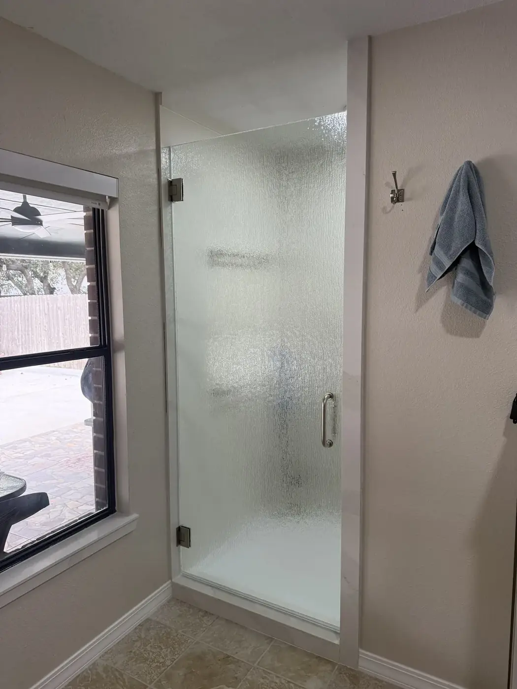 Frameless rain-glass shower door with brushed nickel hardware