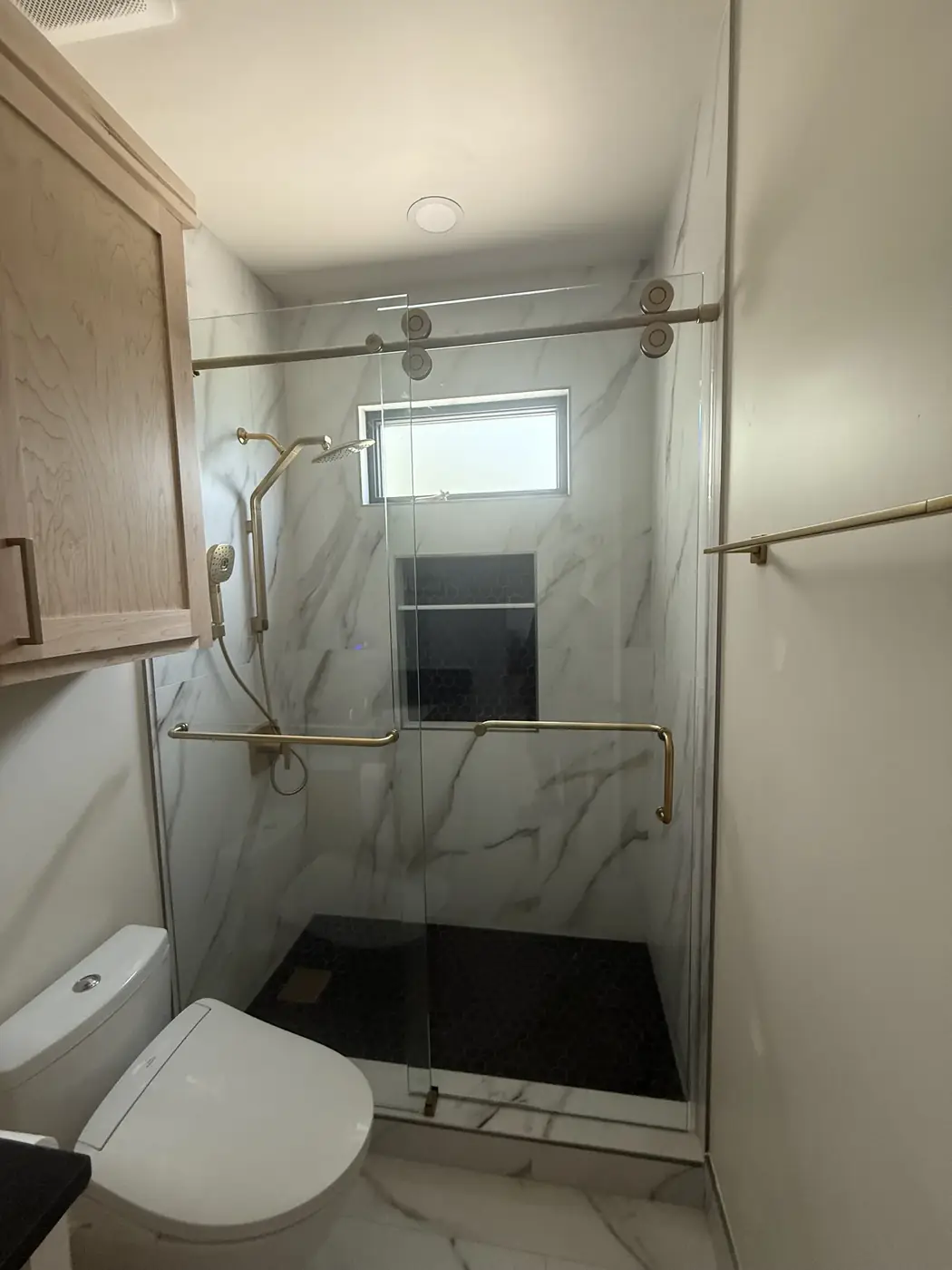 Sliding glass shower with brushed-gold hardware
